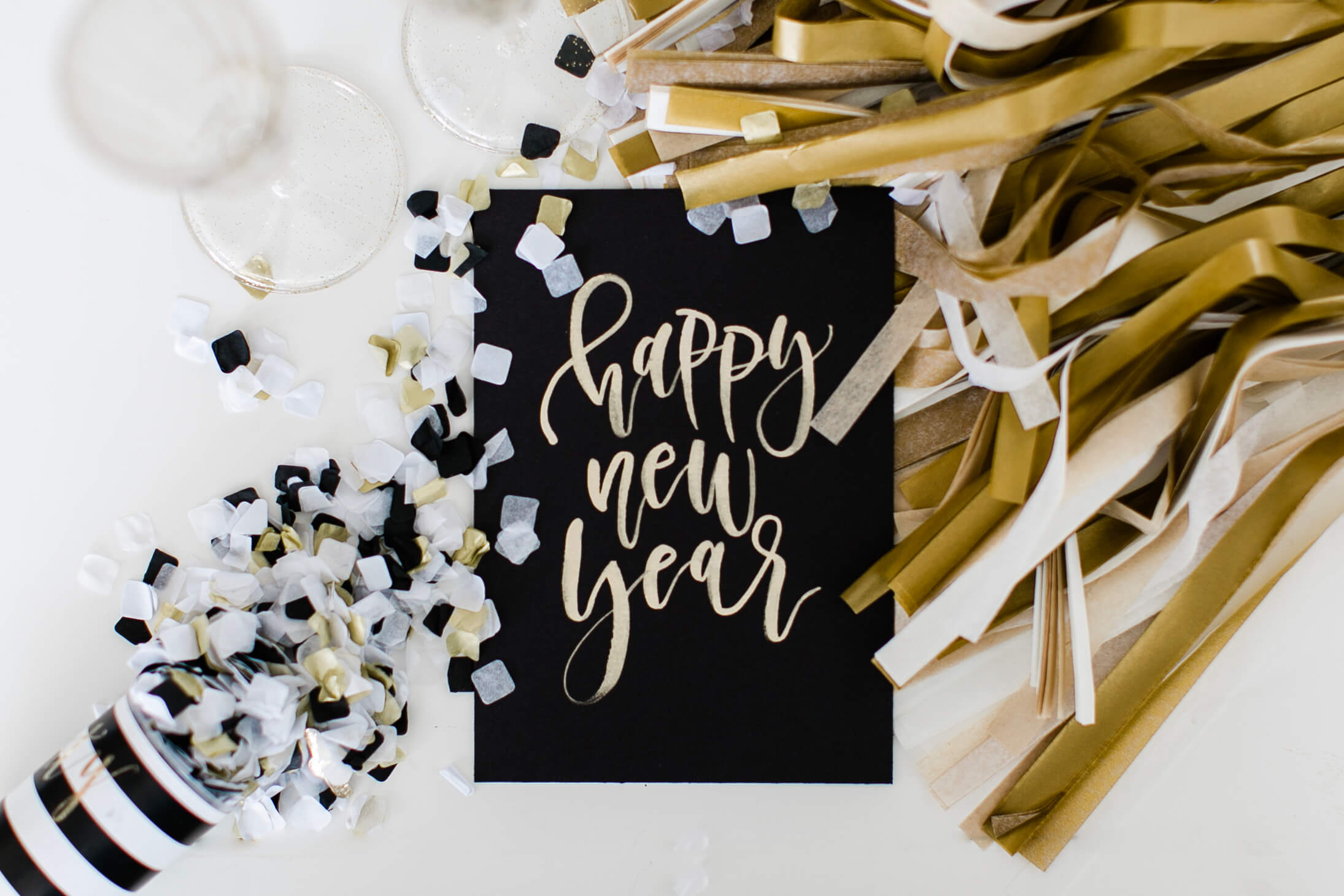 New year card with confetti and champagne glasses.