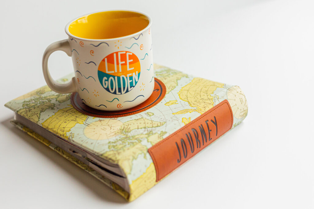 Life is Golden mug on a journey notebook representing the power of holistic wellness coaching